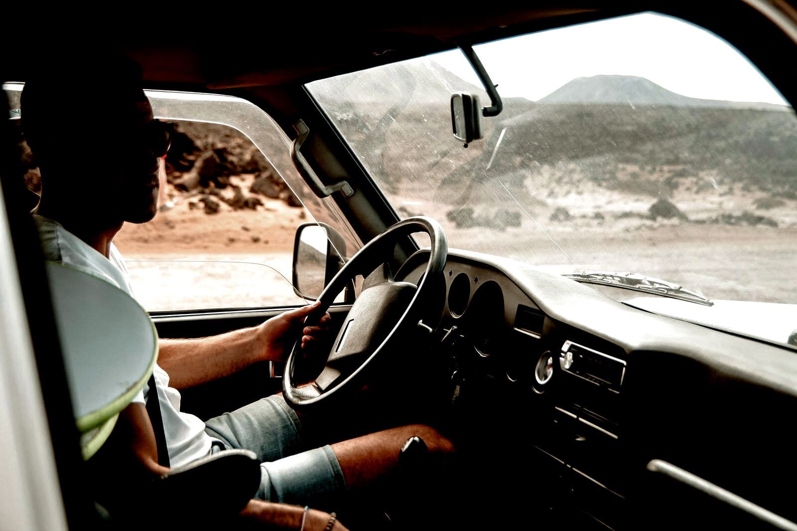 A company driver at the wheel, morning light through the windshield